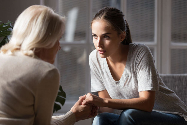 Daughter holding hands aged mother having heart-to-heart talk Daughter holding hands aged mother having heart-to-heart talk