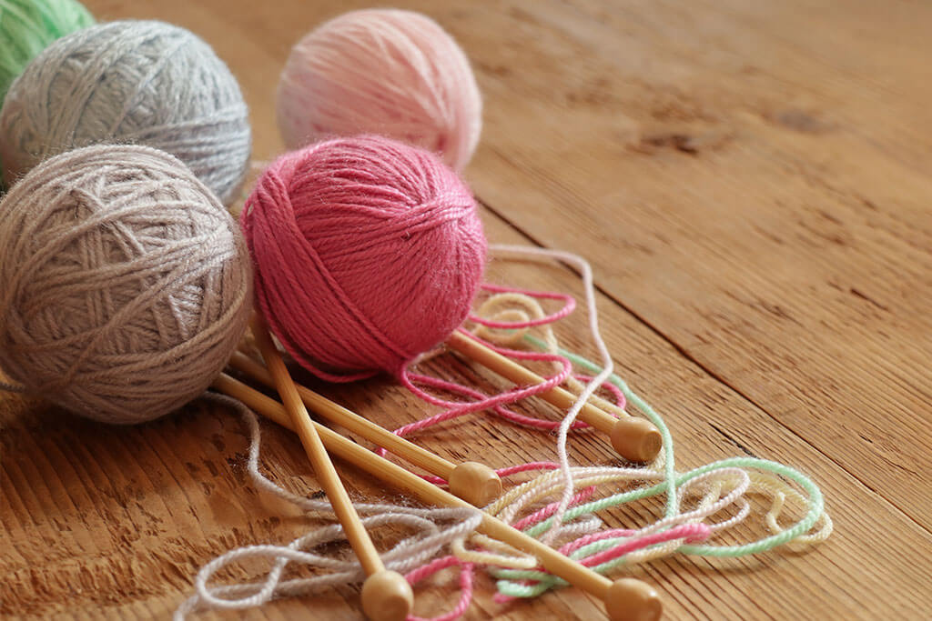 Colorful balls of yarn and knitting needles on wooden Colorful balls of yarn and knitting needles on wooden