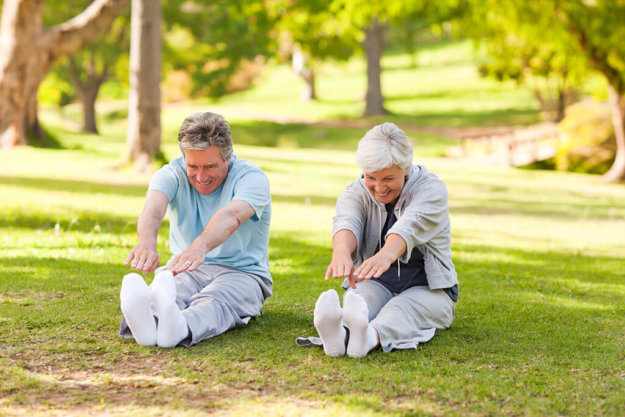 Elderly couple doing their stretches in the park Elderly couple doing their stretches in the park