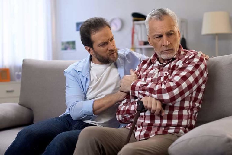 Middle-aged male comforting retiree father, suffering loss of wife, depression