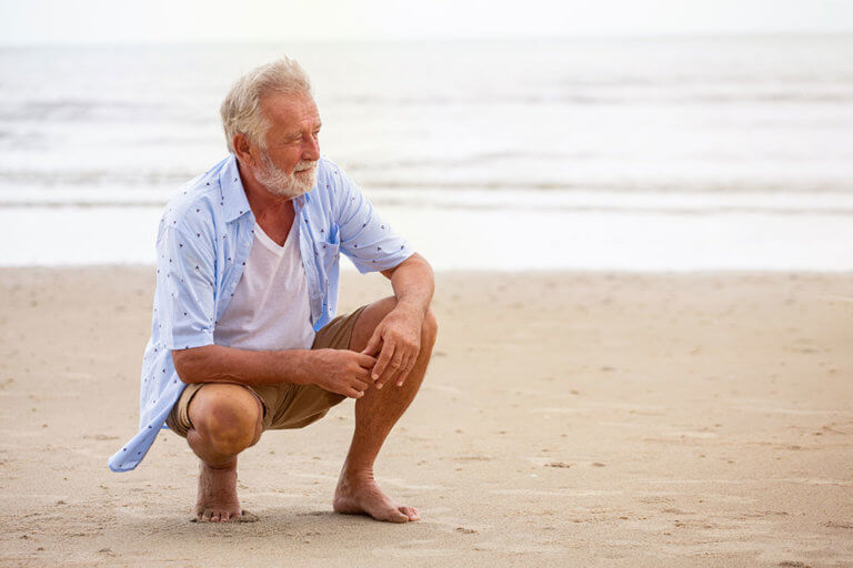 Senior man sitting on beach relaxing