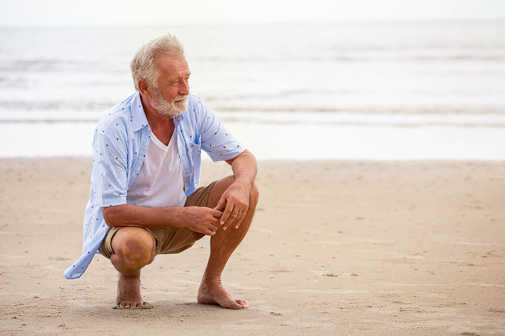 Senior man sitting on beach relaxing Senior man sitting on beach relaxing