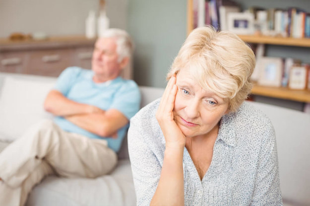 Tensed senior couple sitting on sofa Tensed senior couple sitting on sofa