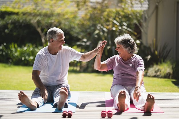 Cheerful senior couple giving high five while exercising Cheerful senior couple giving high five while exercising