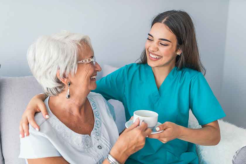 Happy senior woman talking with friendly nurse at geriatric ward Happy senior woman talking with friendly nurse at geriatric ward
