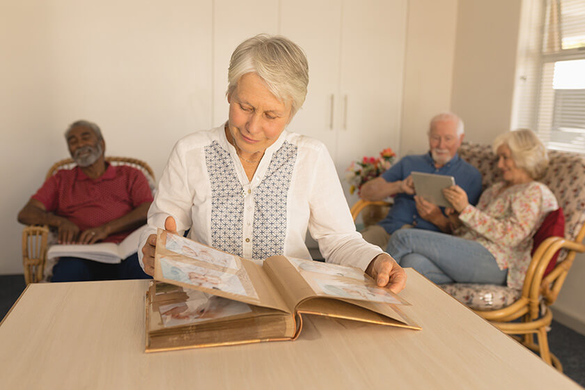 Senior woman looking at photo album in living room