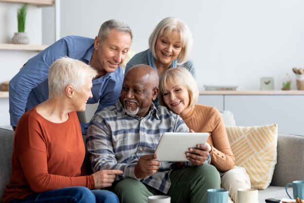 Cheerful elderly people spending time together at home, using gadgets What To Consider When Finding The Right Floor Plans In Retirement Communities Near Harvey, LA