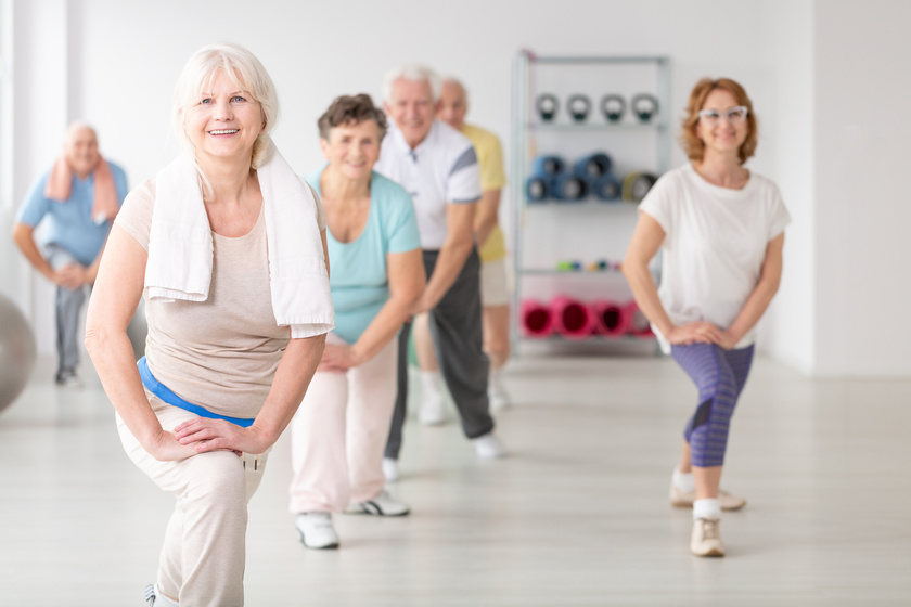 Smiling senior woman with towel exercising during fitness classe Smiling senior woman with towel exercising during fitness classe