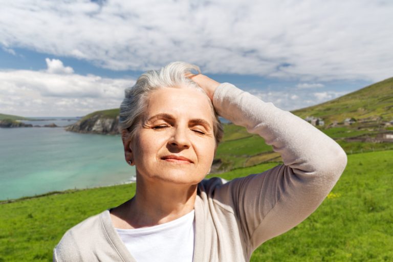 portrait of senior woman enjoying sun on beach