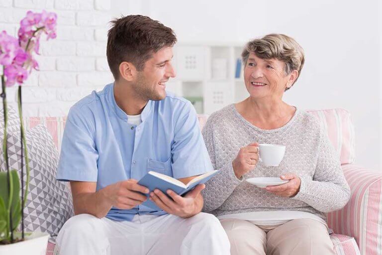 Professional carer reading to senior
