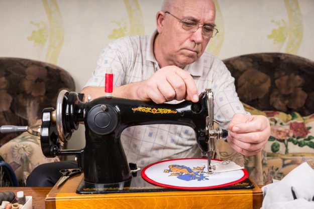 Senior Man Doing Needlepoint on Sewing Machine Senior Man Doing Needlepoint on Sewing Machine