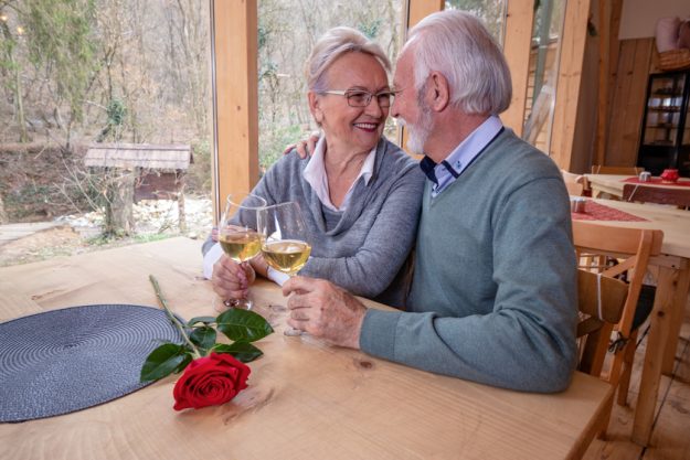 A mature romantic couple of caucasian man and woman sit in a res A mature romantic couple of caucasian man and woman sit in a res