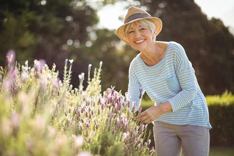 Happy senior woman standing in backyard