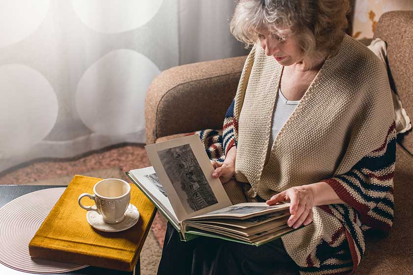 an elderly woman looks at photo albums