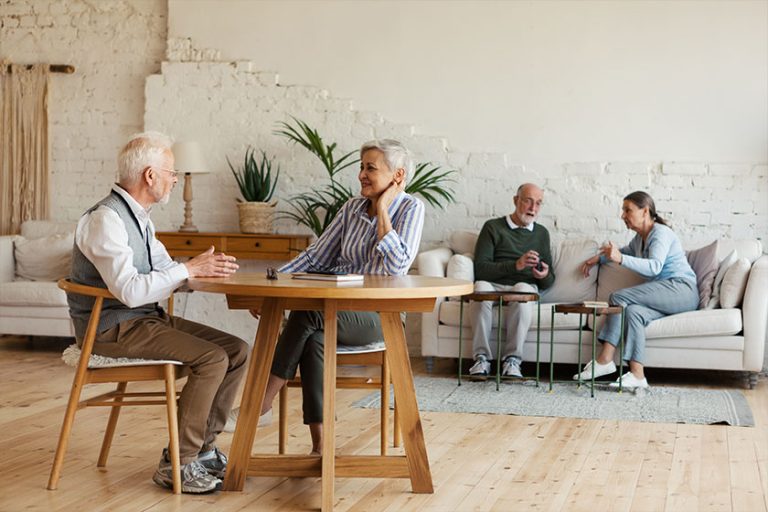enior man and woman sitting at table and enjoying talk