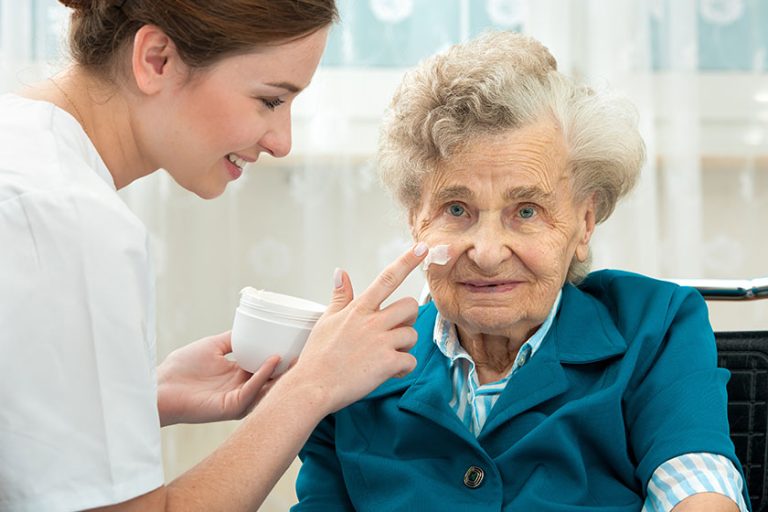 Elderly woman is assisted by nurse at home