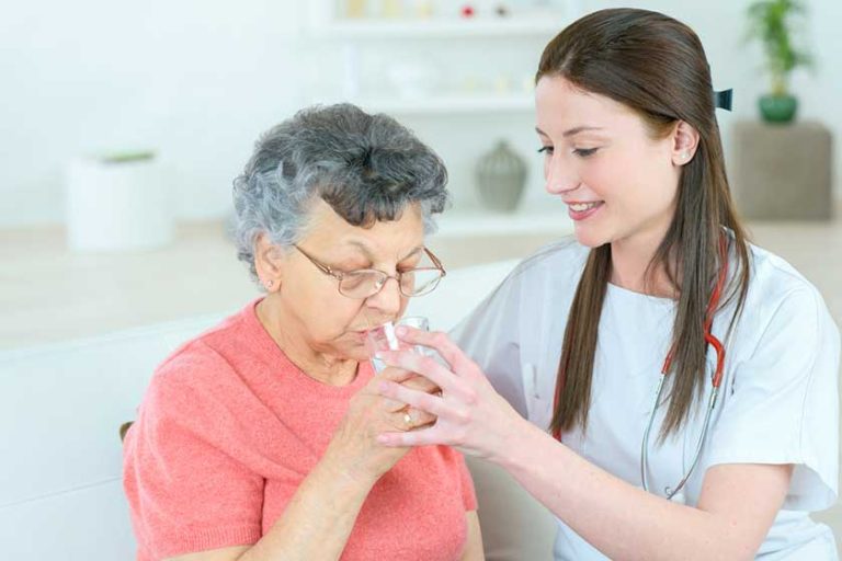 giving senior lady a glass of water