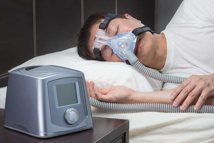 Asian man with sleep apnea using CPAP machine Asian man with sleep apnea using CPAP machine