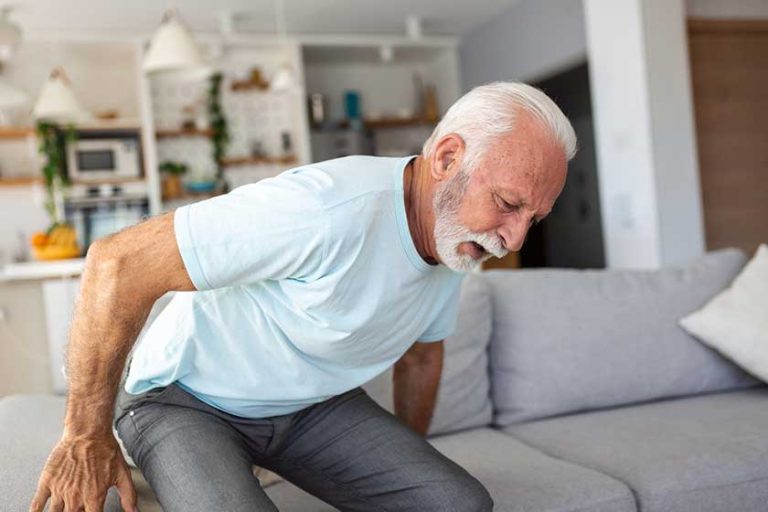 Senior elderly man touching his back, suffering from backpain
