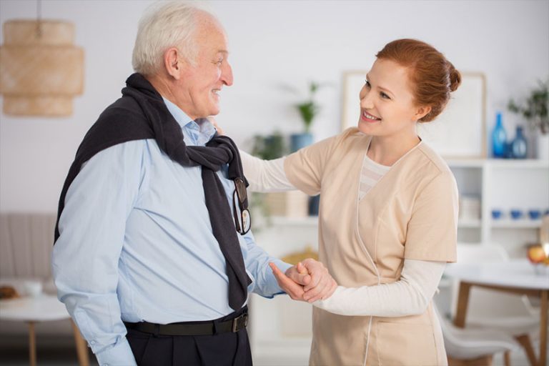 caregiver helping a senior man