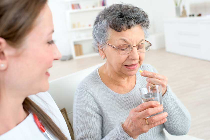 Doctor giving medication to an old lady