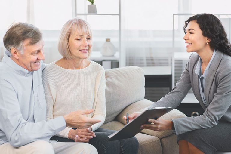 Senior couple consulting with adviser at office