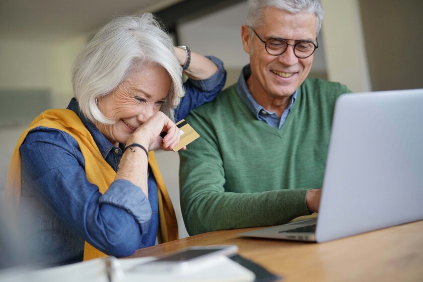 Happy senior couple online shopping at home Happy senior couple online shopping at home