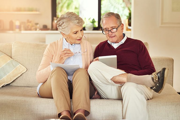 Shot of an elderly couple working out a budget while sitting on the living room sofa.