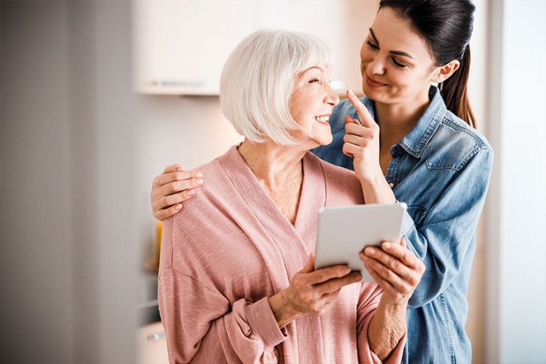 Happy grandmother and adult granddaughter having fun at home