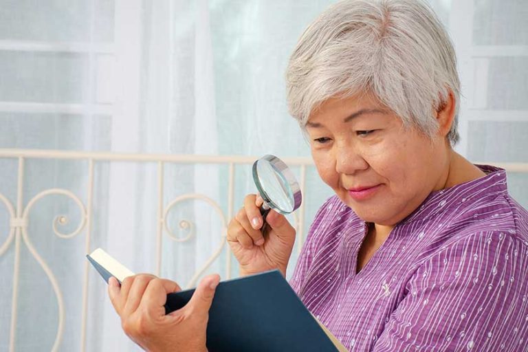 Portrait of senior woman with a magnifying glass