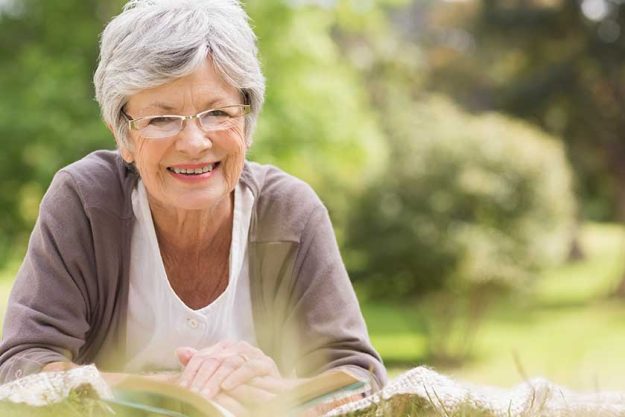 Senior woman reading a book at park Senior woman reading a book at park