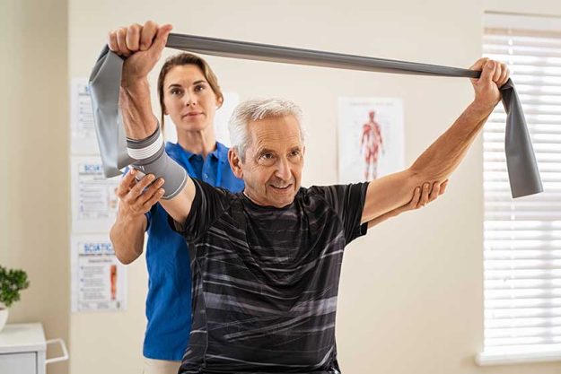 Young physiotherapist working with senior patient