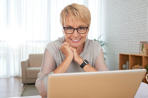 Cheerful Senior Woman Enjoying Watching Movie Laptop Screen