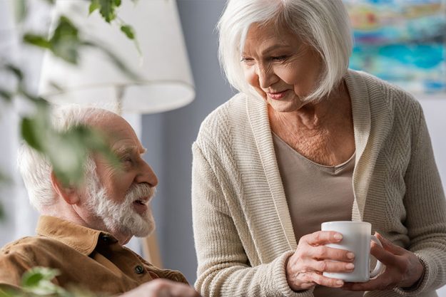 Smiling Senior Woman Holding Cup Tea While Talking Smiling Senior Woman Holding Cup Tea While Talking