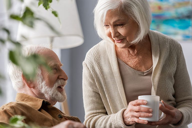 Smiling Senior Woman Holding Cup Tea While Talking
