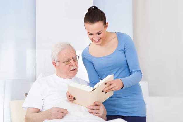 caretaker-and-senior-man-reading caretaker-and-senior-man-reading