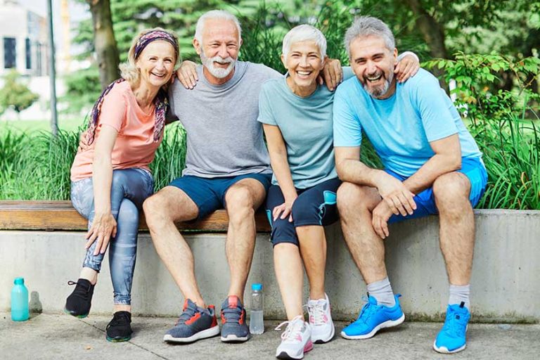 Smiling active senior people posing together in the park