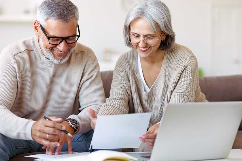 Smiling senior couple calculate expenses or planning