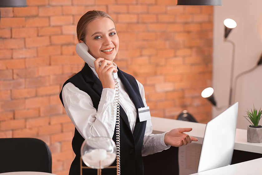 Young female receptionist talking by telephone Young female receptionist talking by telephone