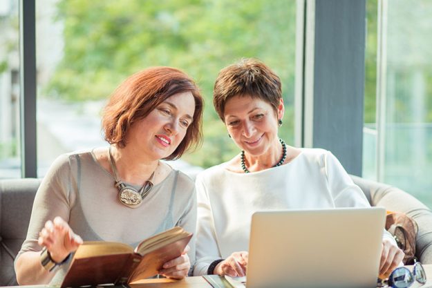 Elegant mature women sharing laptop Elegant mature women sharing laptop
