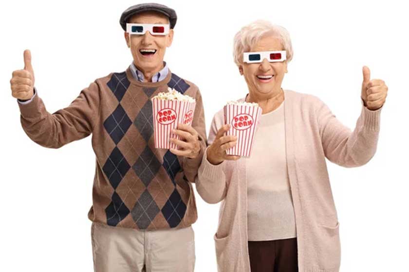 Seniors with 3D glasses and popcorn making thumb up