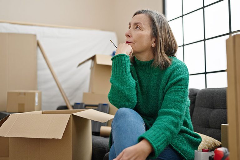 Mature hispanic woman with grey hair sitting on sofa
