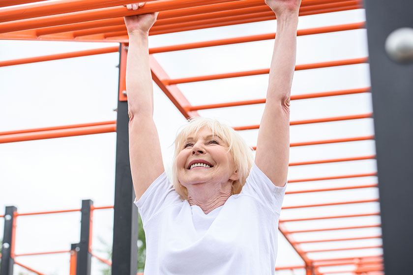 cheerful senior woman exercising sports ground