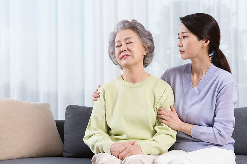 depressed asian old mother comforted middle aged daughter
