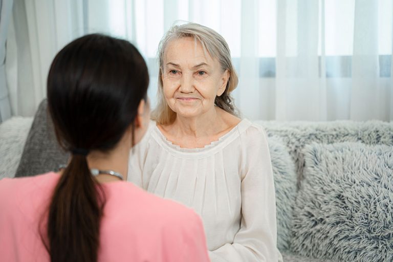 professional helpful caregiver comforting senior woman nursing home senior services