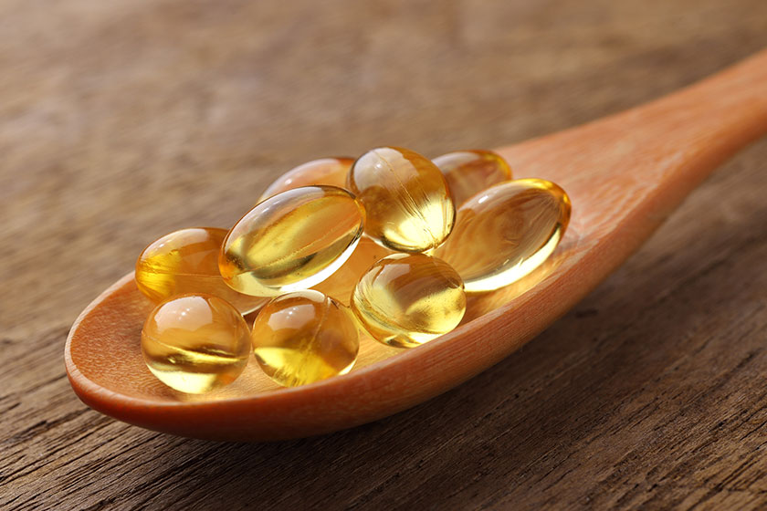 fish oil capsules in a spoon