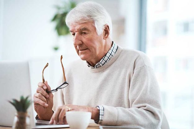 handsome senior businessman working his laptop home