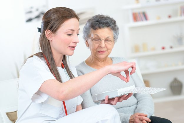 nurse discussing medication with elderly woman