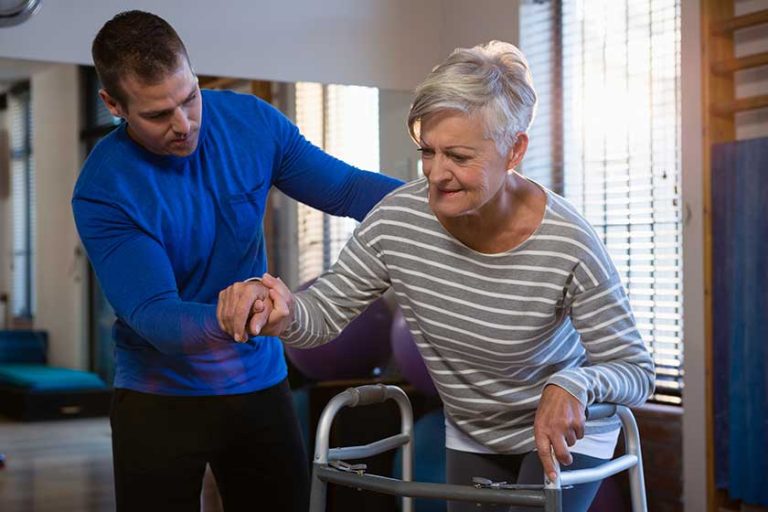 physiotherapist assisting patient to walk