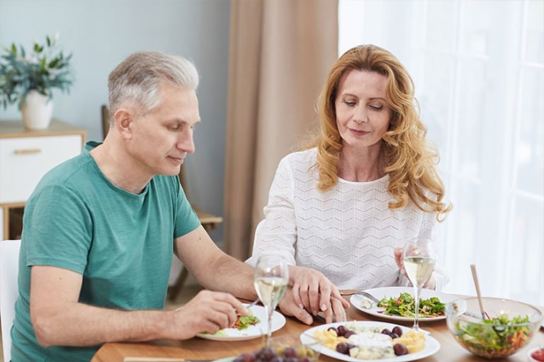 portrait modern mature couple holding hands while enjoying healthy dinner